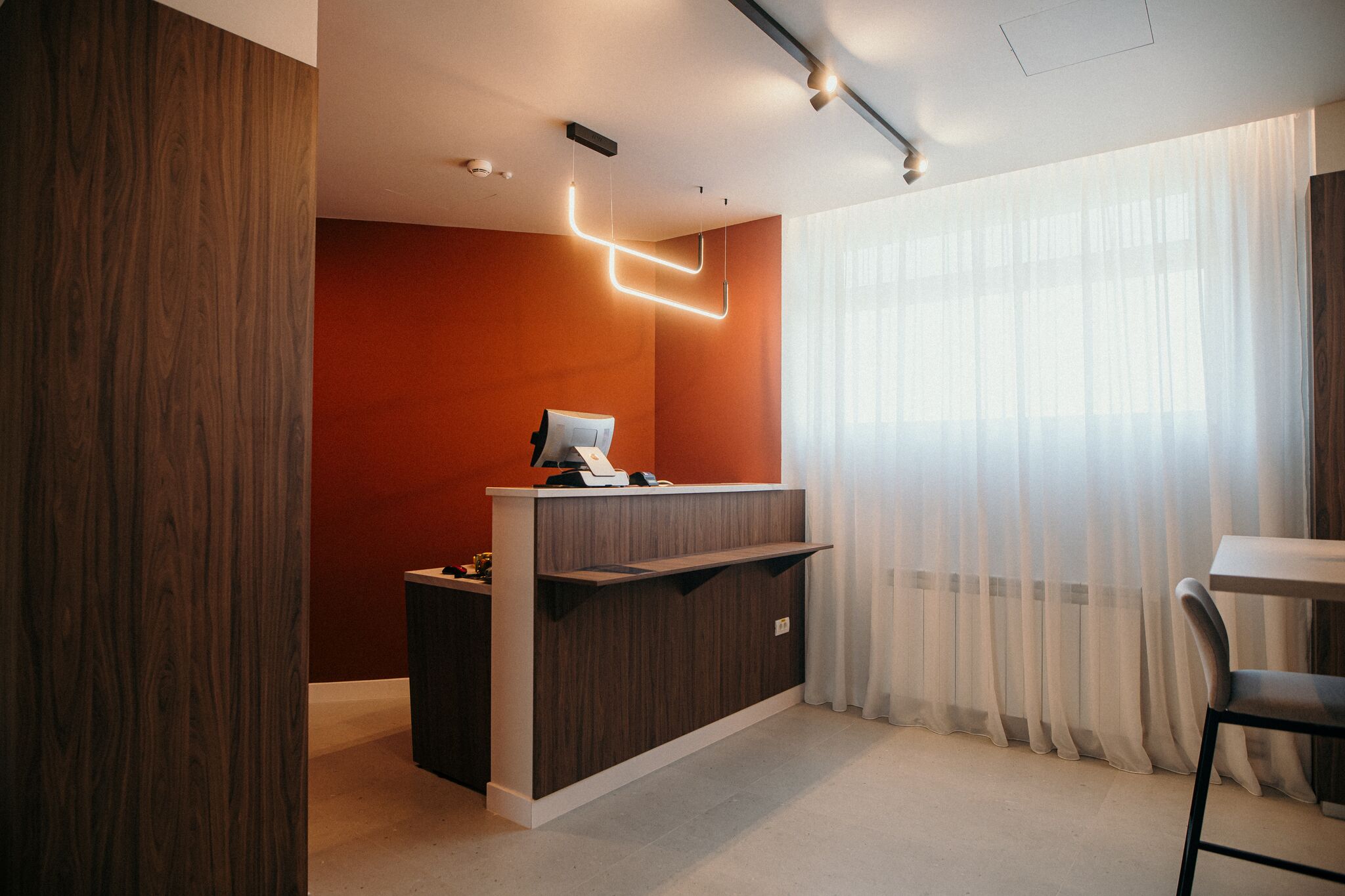 Receptia cu perete portocaliu si iluminat ambiental — Grey Residence, Drobeta-Turnu Severin