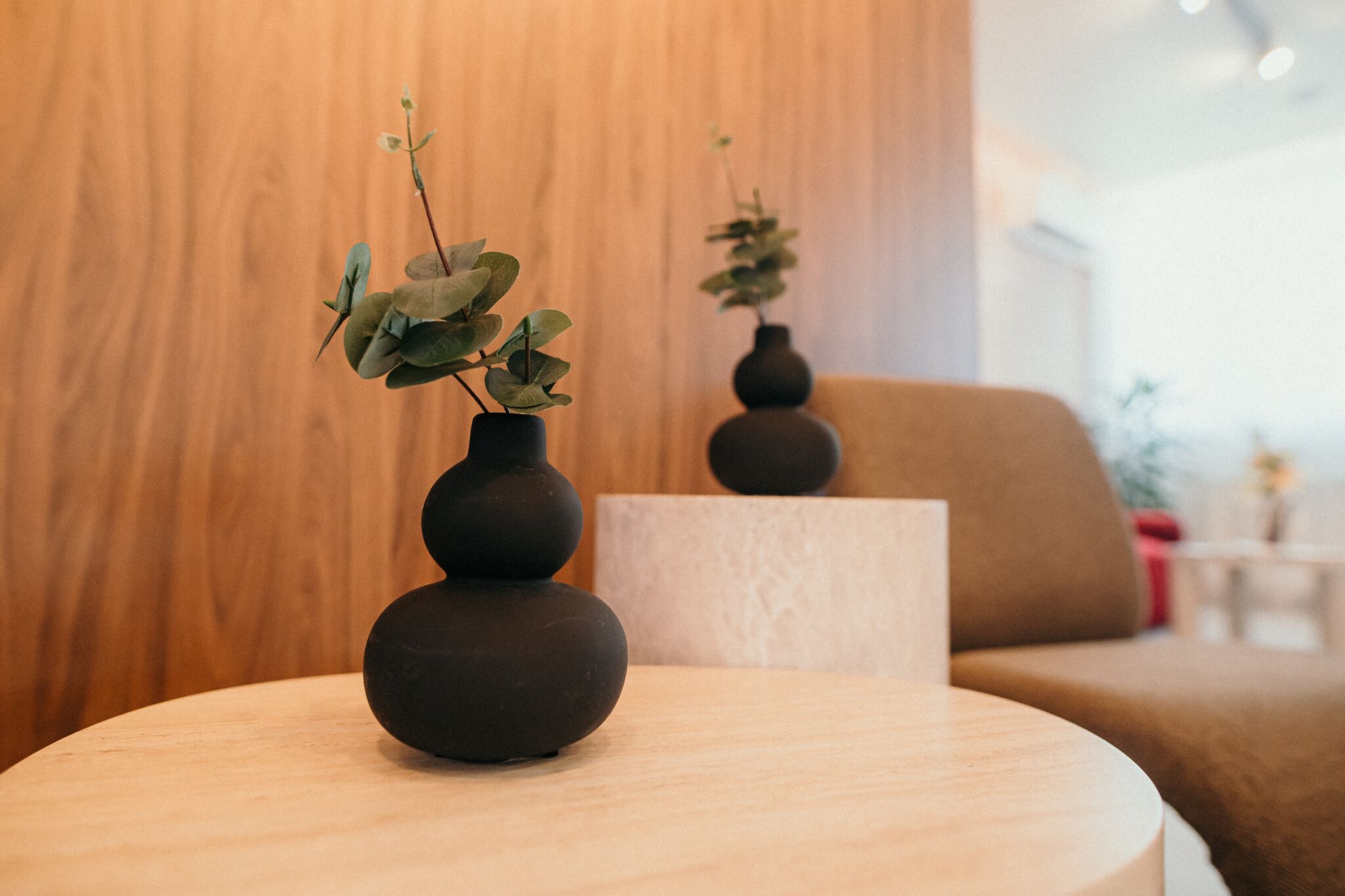 Vaze ceramice negre cu eucalipt pe masa de travertin — Grey Residence, Drobeta-Turnu Severin