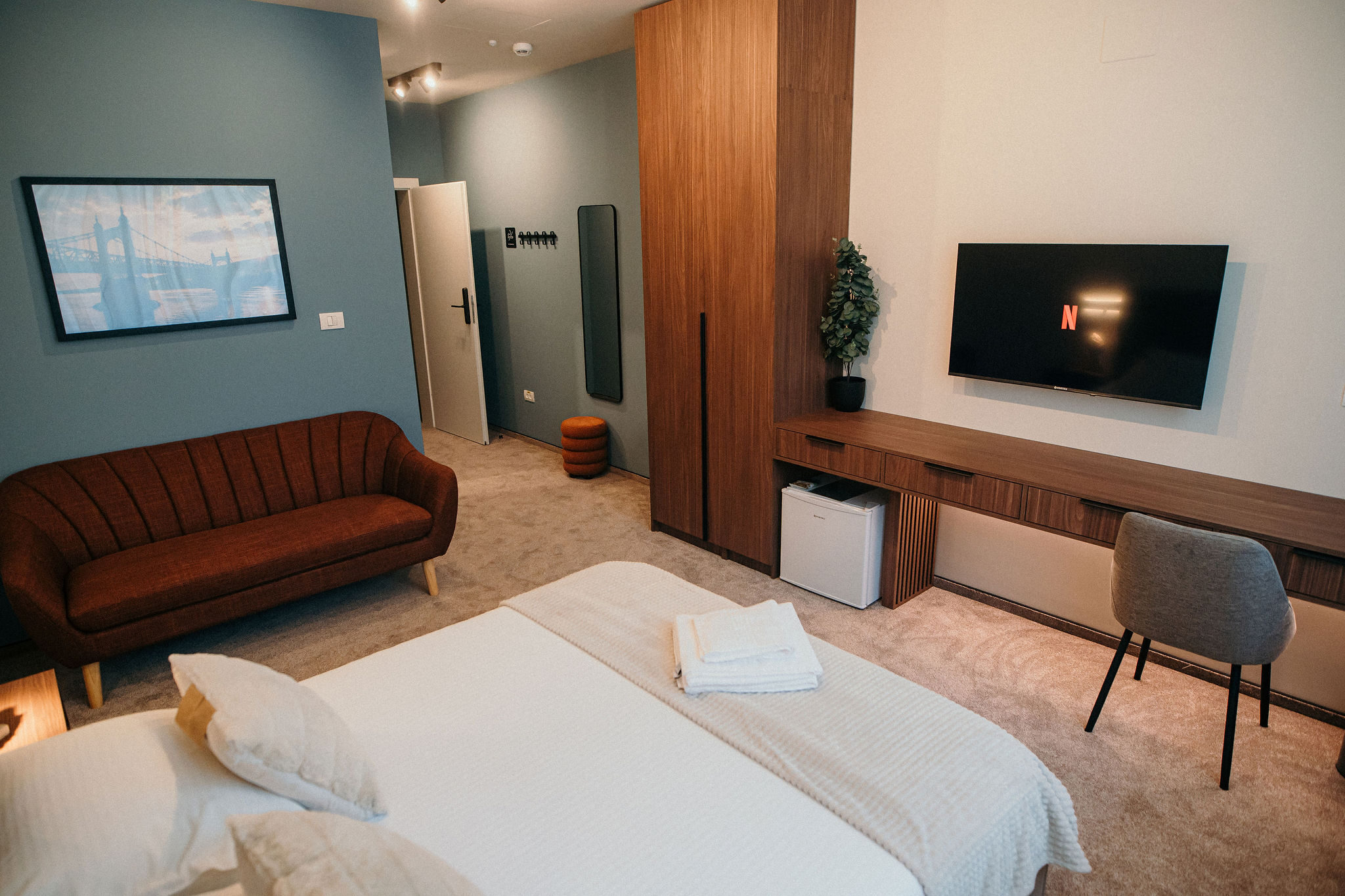 Zona de ședere cu canapea, birou de lucru și Smart TV în camera King Deluxe
